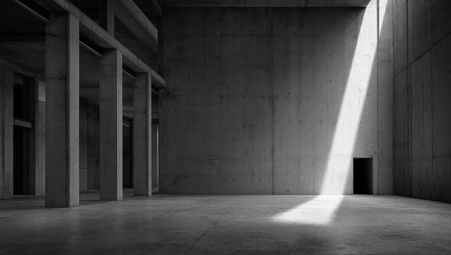 Leere Betonhalle mit hartem Lichteinfall, monochrom